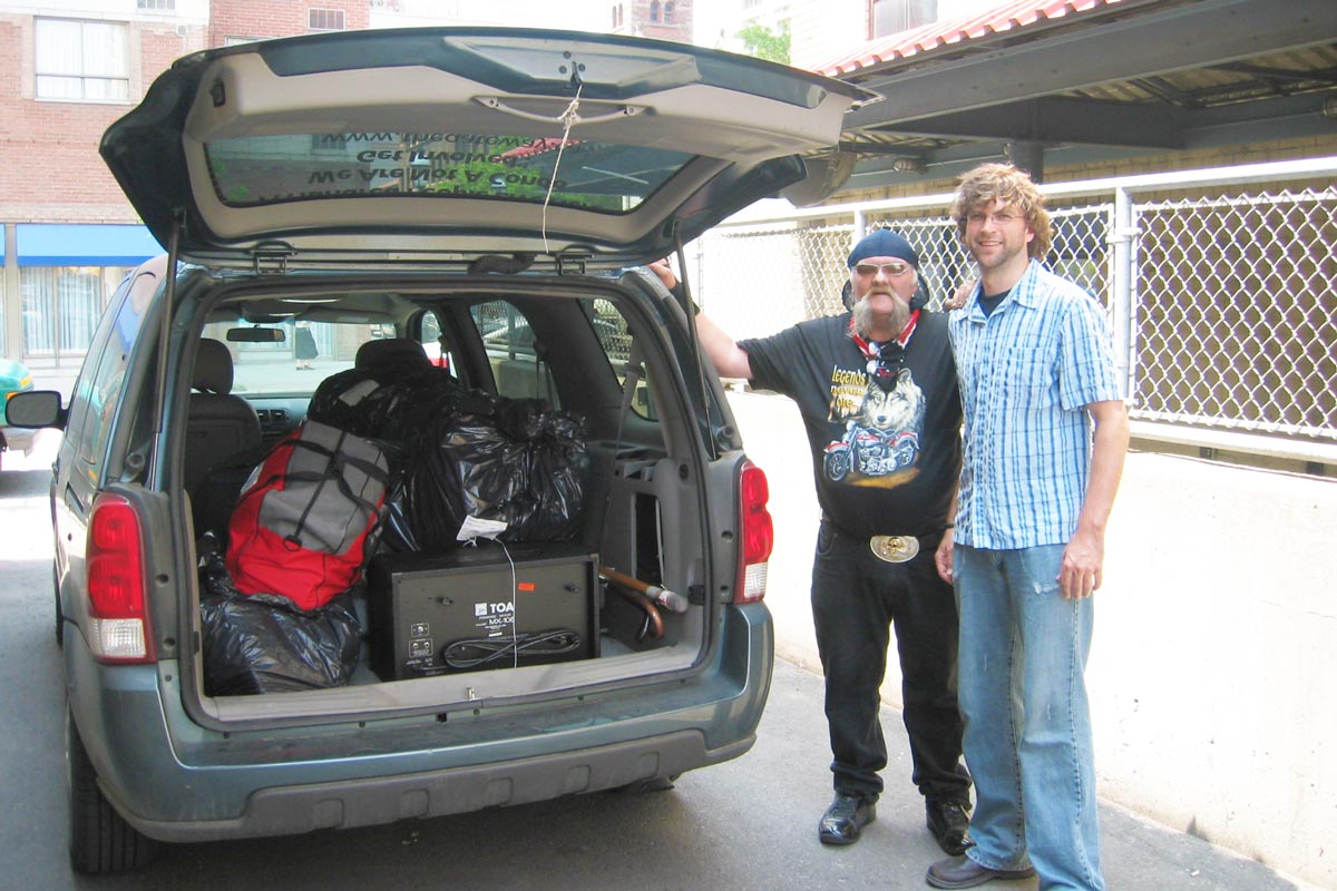 image of two men by a van